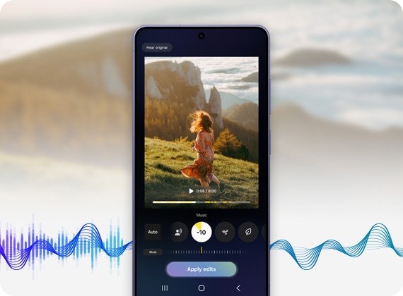 هاتف جالاكسي إس26 إلترا يعرض كيفية استخدام Audio Eraser لتحرير فيديو لشخص في أجواء عاصفة بالخارج. يظهر زر "تطبيق" التعديلات. موجات صوتية تدخل بشكل عشوائي إلى Audio Eraser وتخرج بانسيابية، لتوضيح كيف ينقي الصوت.